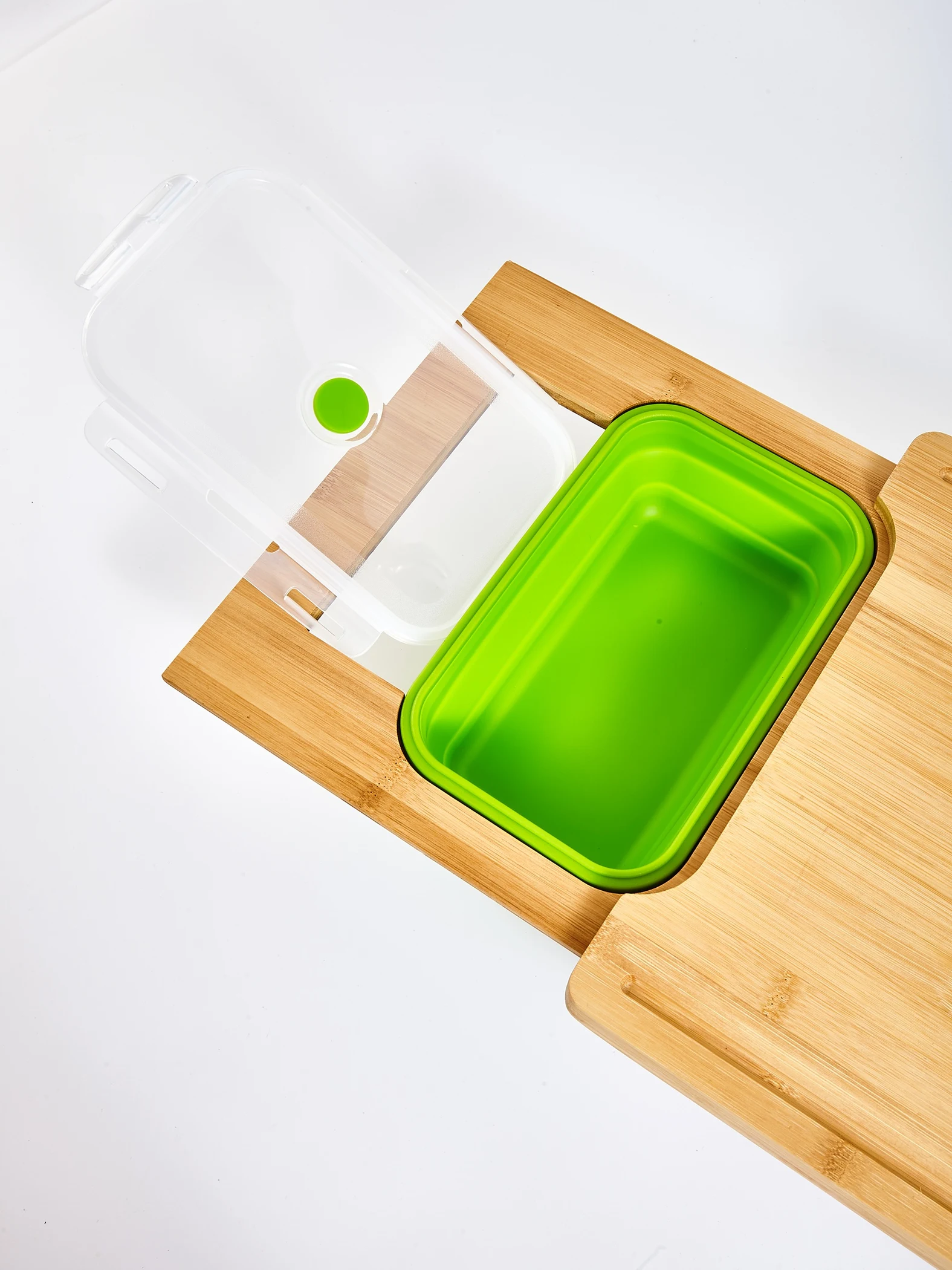 Green storage container seated in the board with lid open beside it